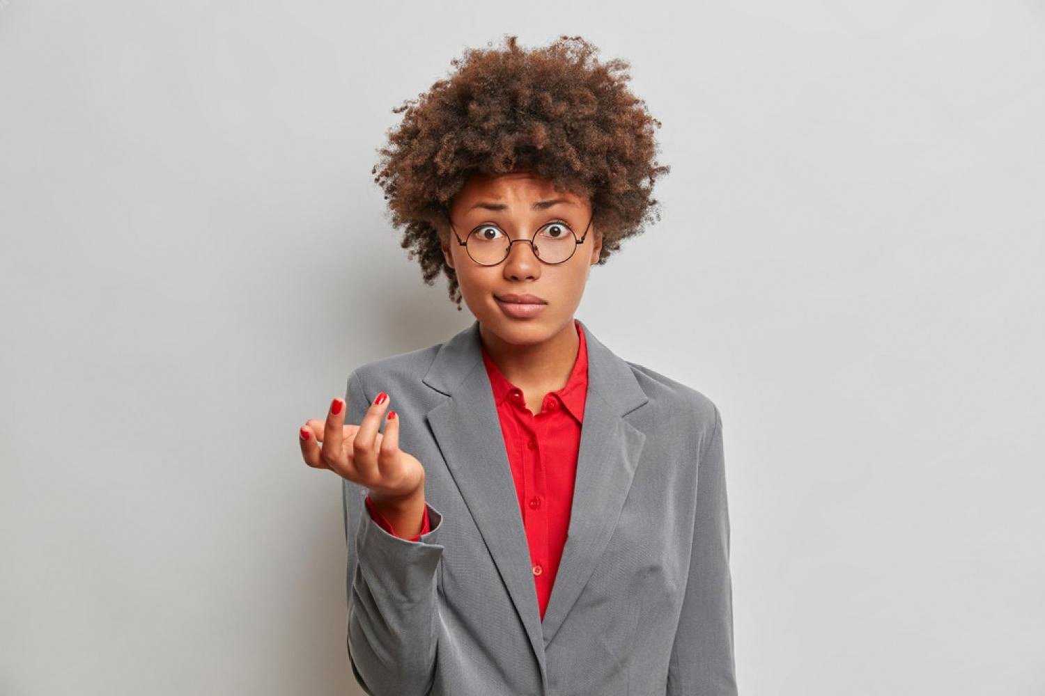 Confused woman in a grey blazer shrugging, unsure about a company with no online presence